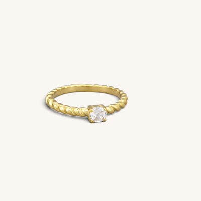Gold tone stainless steel twisted solitaire ring with a clear cubic zirconia