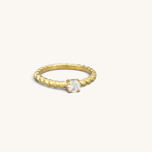Gold tone stainless steel twisted solitaire ring with a clear cubic zirconia